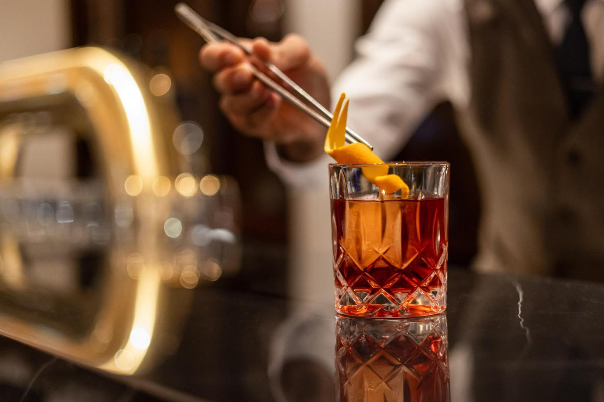Intercontinental Berlin By Ihg Hotel Luaran gambar A bartender adding a lemon twist to a cocktail